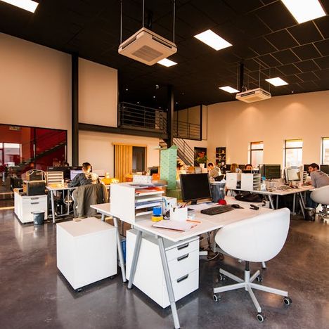 Open-plan office with people working across shared desks